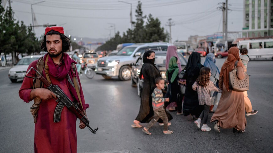 A member of Taliban stands guard along a road in Kabul on Sept. 30, 2021. 