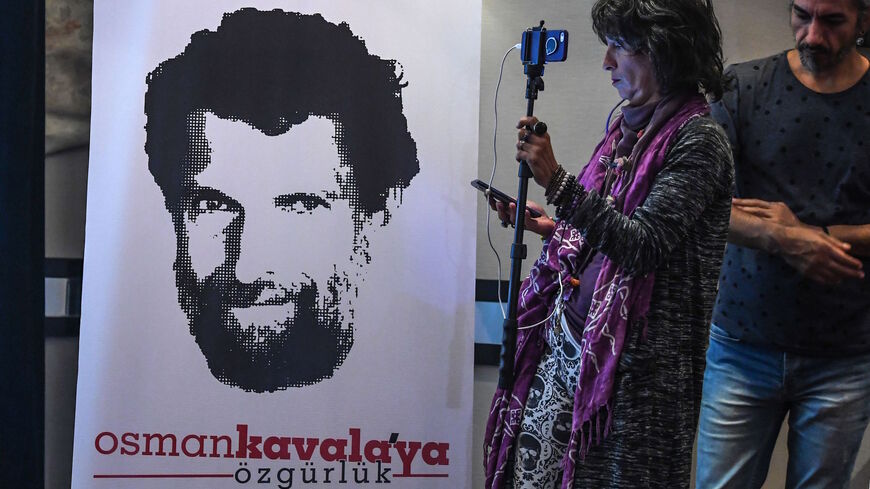 A journalist stands in front of a poster featuring jailed businessman and philanthropist Osman Kavala during a press conference of his lawyers on Oct. 31, 2018.  