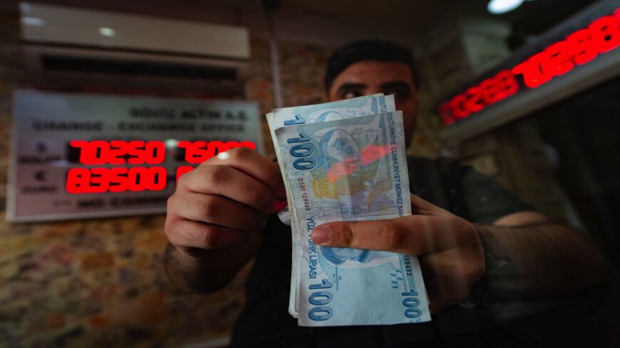 A currency exchange office worker counts Turkish lira banknotes.