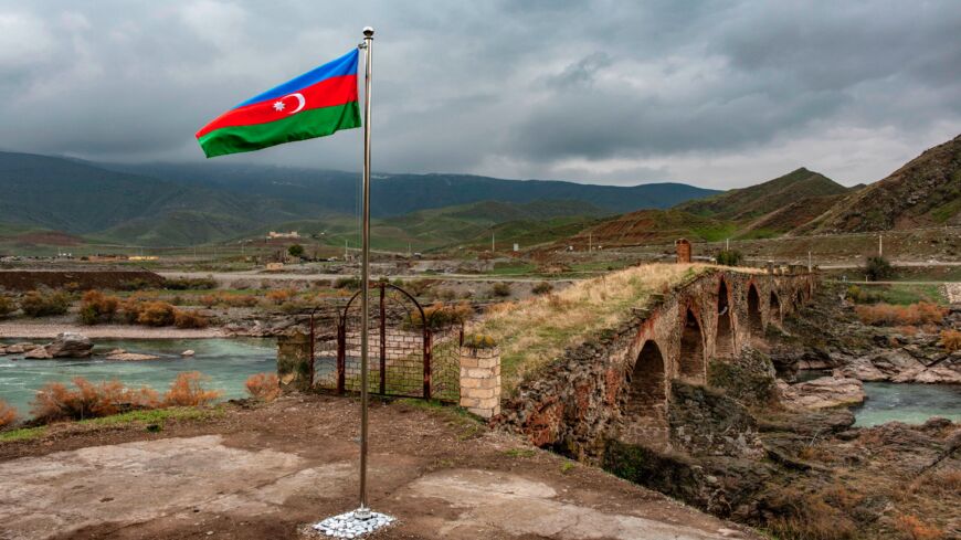 An Azerbaijani national flag flies next to the medieval Khudaferin bridge in Jebrayil district at the country's border with Iran, on Dec. 9, 2020.
