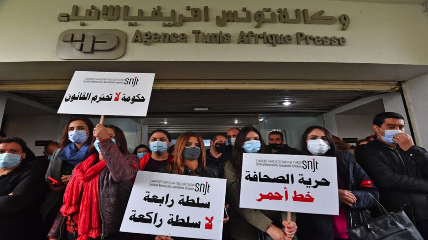 Journalists hold up signs reading in Arabic (R to L) "freedom of the press is a red line."