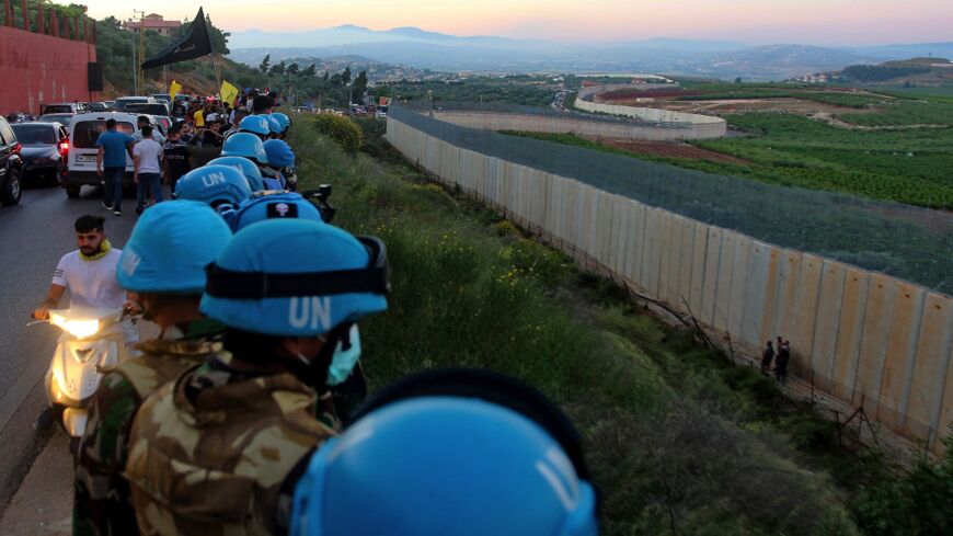 United Nations peacekeeping force in Lebanon (UNIFIL) soldiers stand along the border wall with Israel, in the Lebanese village of Adaiseh, on May 15, 2021. 