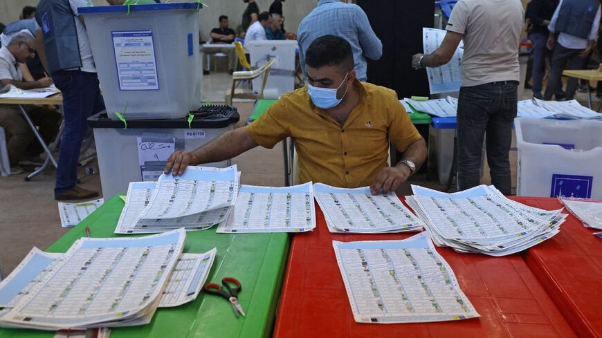 Employees of Iraq's Independent High Electoral Commission conduct a manual count of votes following the parliamentary elections in Baghdad's Green Zone area on Oct. 13, 2021. 