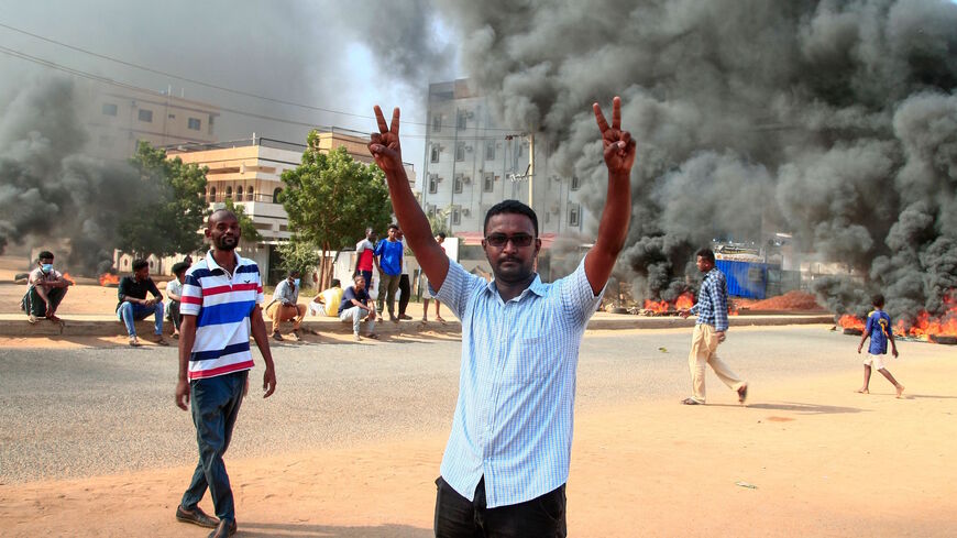 A Sudanese demonstrator flashes the victory sign during a demonstration in the capital Khartoum, on Oct. 25, 2021, to denounce overnight detentions by the army of members of Sudan's government.