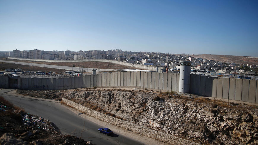 A general view shows a section of Israel's controversial separation wall near Qalandia crossing between the West Bank city of Ramallah and Israel-annexed East Jerusalem. The tarmac of the former Atarot airport, which has been closed to civilian traffic since the breakout of the second Palestinian intifada in 2000, can be seen in the center, July 28, 2016.