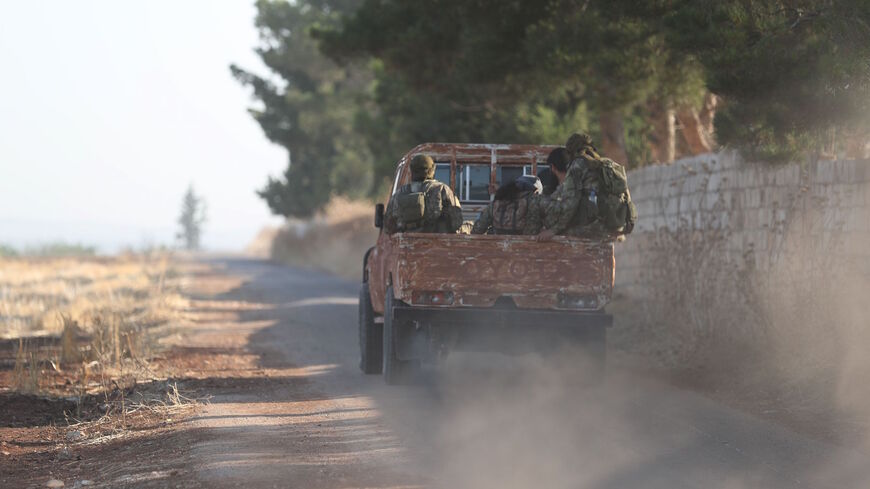 Fighters from the former al-Qaeda Syrian affiliate Hayat Tahrir al-Sham (HTS) drive through the village of Hamameyat on the border between Hama and Idlib provinces on July 11, 2019.