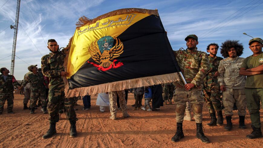 Members of the special forces of the self-proclaimed Libyan National Army, loyal to eastern strongman Khalifa Hifter, pose with their flag in the eastern city of Benghazi on Nov. 6, 2020.