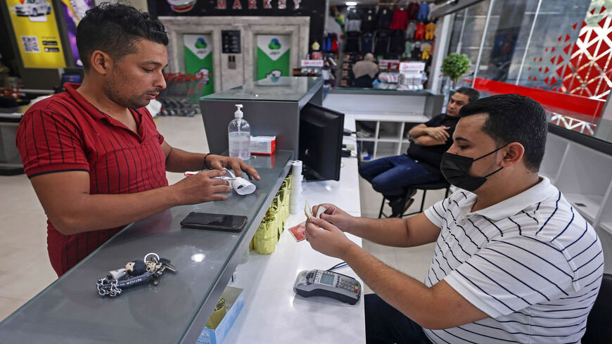 A Palestinian man receives financial aid at a supermarket as part of the United Nations Humanitarian Cash Assistance program, supported by Qatar, Gaza City, Gaza Strip, Sept. 15, 2021.