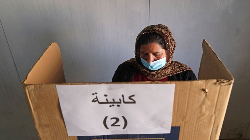 A displaced Yazidi casts her vote for the parliamentary elections at a camp some 15 kilometers from the northern city of Dahuk in the autonomous Iraqi Kurdistan region, on Oct. 8, 2021. 