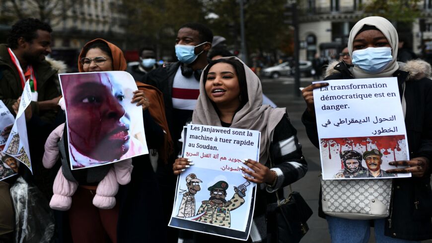 Protestors hold placards and photographs as they shout slogans during a rally to denounce the Sudanese military coup.