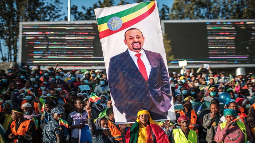 A woman holds a banner with the portrait of Primer Minister Abiy Ahmed during a rally in Addis Ababa, Ethiopia, on Nov. 7, 2021.