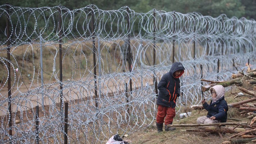 A picture taken on Nov. 12, 2021 shows migrants in a camp on the Belarusian-Polish border in the Grodno region. - Hundreds of desperate migrants are trapped in freezing temperatures on the border and the presence of troops from both sides has raised fears of a confrontation. 