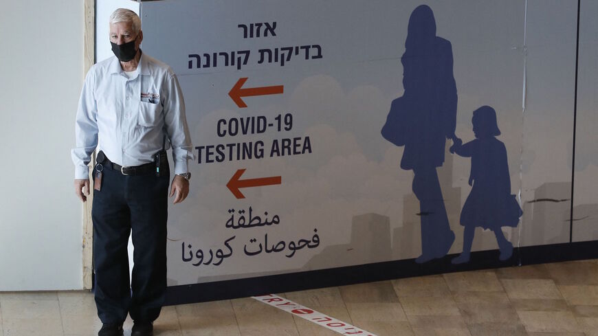 A staff member assists arriving passengers at Israel's Ben Gurion Airport in Lod, east of Tel Aviv, on Nov. 28, 2021.