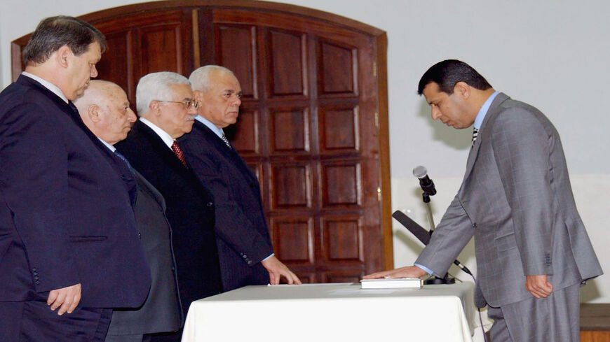 Palestinian Civil Affairs Minister Mohammed Dahlan takes the oath of office as Prime Minister Ahmed Qurei (second L), President Mahmoud Abbas (third L) and other officials look on, Ramallah, West Bank, Feb. 24, 2005.