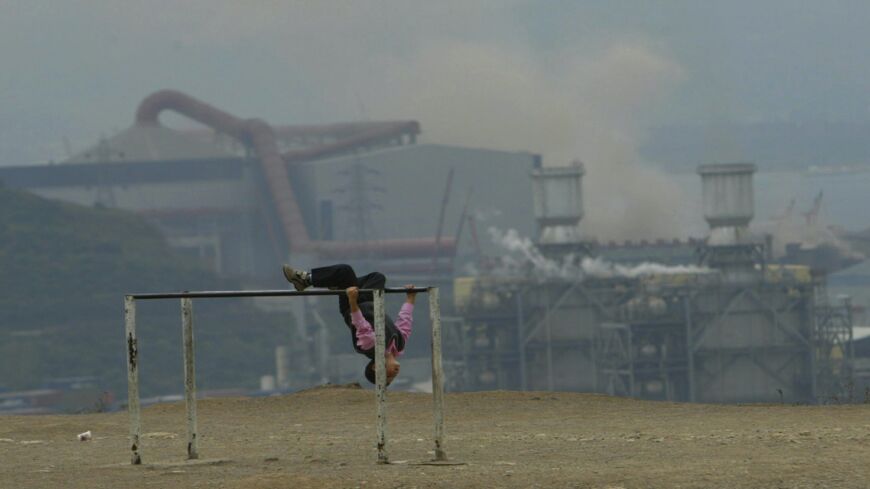 A child plays under the heavy smoke of factories in Dilovasi, Nov. 7, 2006. 
