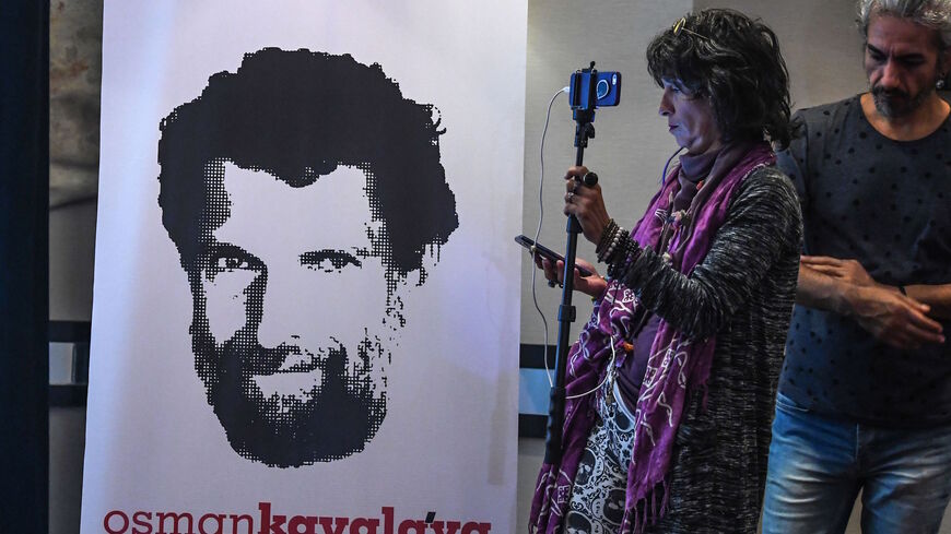 A journalist stands in front of a poster featuring jailed businessman and philanthropist Osman Kavala during a press conference of his lawyers on Oct. 31, 2018. 