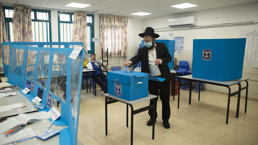 An Orthodox Jewish man casts his vote as Israelis head to the polls on March 23, 2021 in Bnei Brak, Israel.