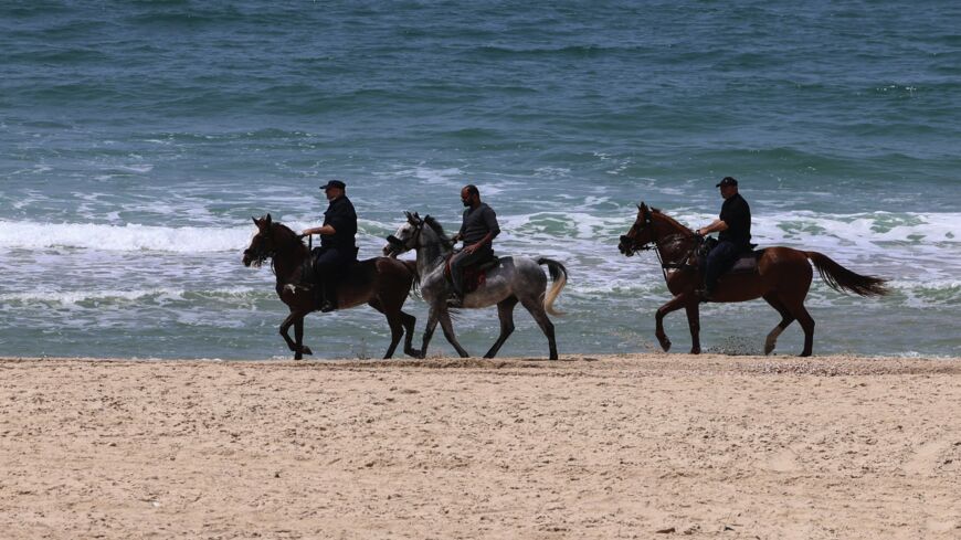 Members of the security forces of the Hamas movement patrol on horseback during a military drill.