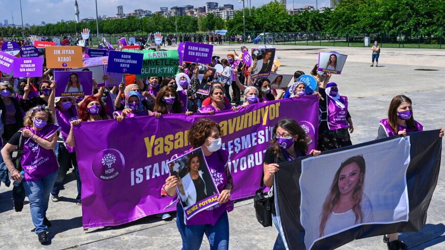 Women hold a banner with the picture of Deniz Poyraz who was killed at Peoples' Democratic Party (HDP) Izmir headquarters, June 19, 2021.