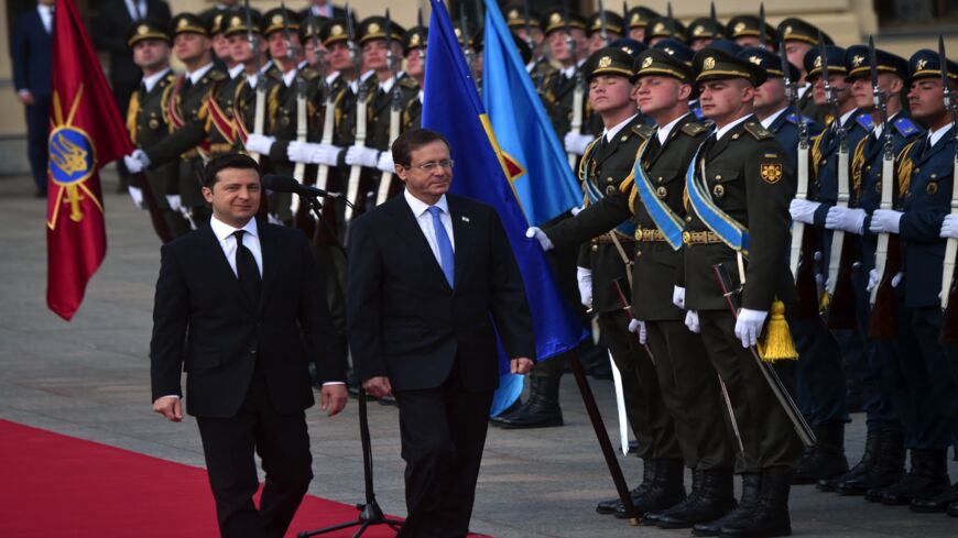 Ukrainian President Volodymyr Zelensky (L) and his Israeli counterpart, Isaac Herzog (C), review a guard of honor.