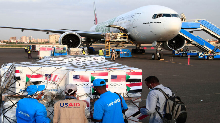 Aid workers check a shipment of coronavirus vaccines sent through the COVAX vaccine-sharing initiative, shortly after an Emirates plane landed at the airport in Khartoum, Sudan, Oct. 6, 2021.