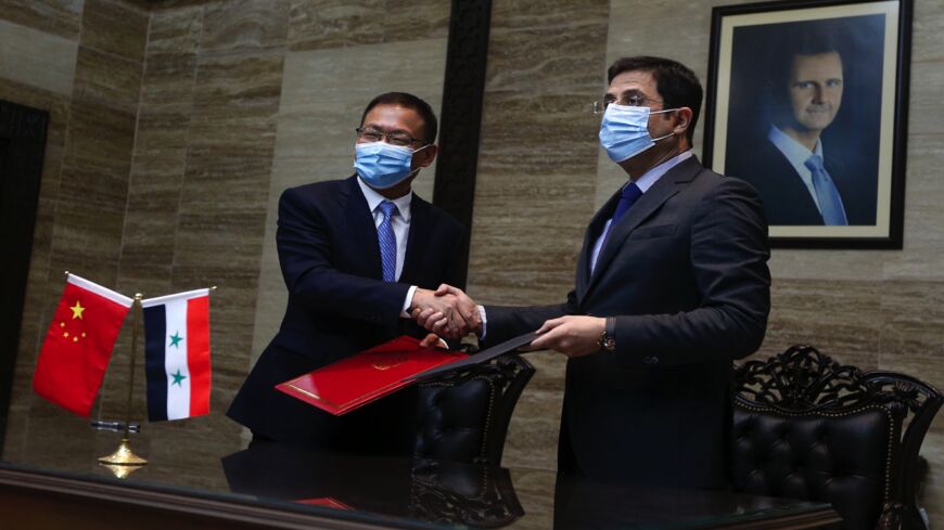 Syrian Health Minister Hassan al-Ghabash (R) and the Chinese Ambassador in his country Feng Biao (L) take part in a ceremony upon the arrival of Sinopharm Covid-19 vaccine, in the capital, Damascus, on Nov. 14, 2021.