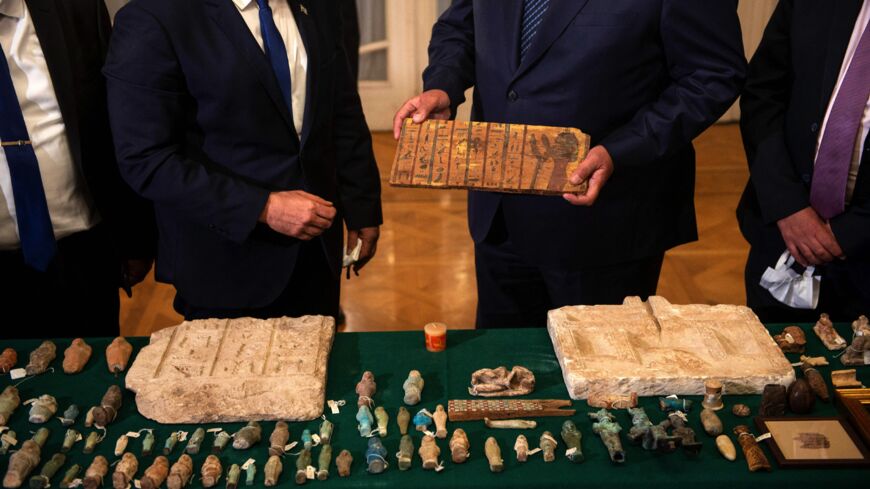 Israeli Foreign Minister Yair Lapid (L) presents Egypt's Foreign Minister Sameh Shoukry (R) with stolen Egyptian artifacts that were smuggled to Israel, at Tahrir Palace in Cairo on Dec. 9, 2021.