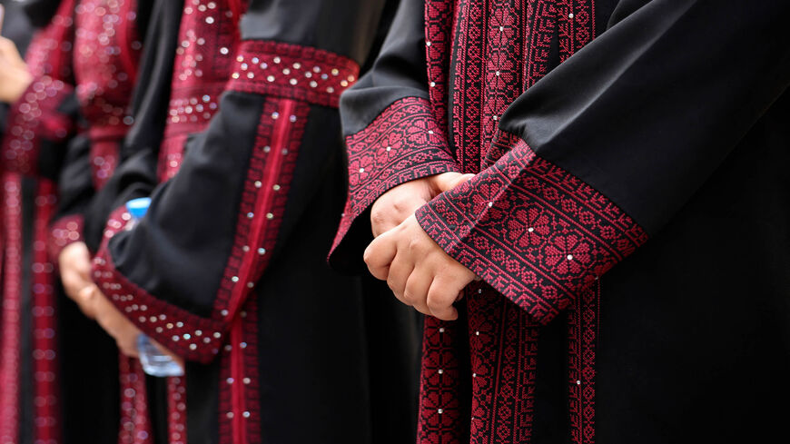 Palestinian university students wearing traditional embroidered dresses take part in an event titled "Don't Steal Our Heritage," Gaza City, Gaza Strip, Dec. 16, 2021.