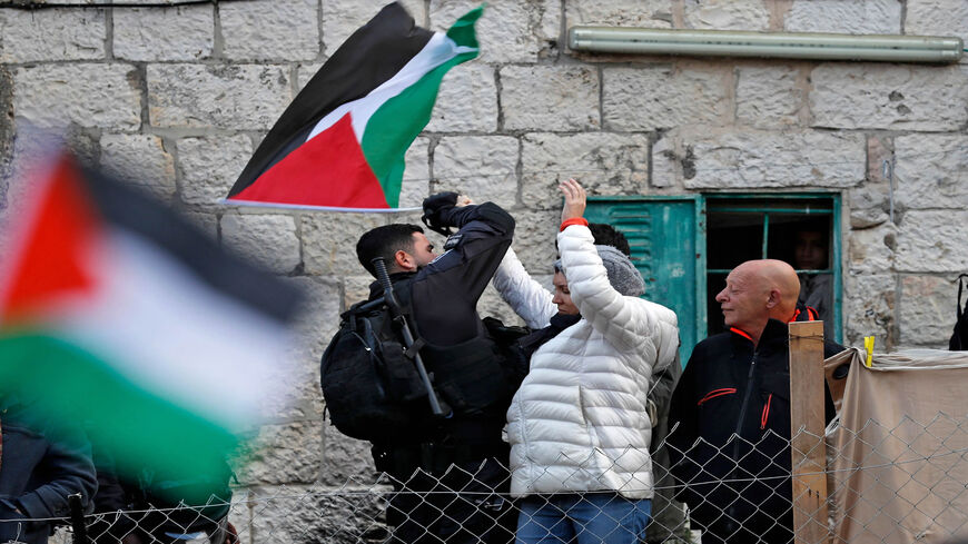 A Palestinian resident scuffles with a member of Israeli security forces during a demonstration in the East Jerusalem neighborhood of Sheikh Jarrah, Dec. 17, 2021.