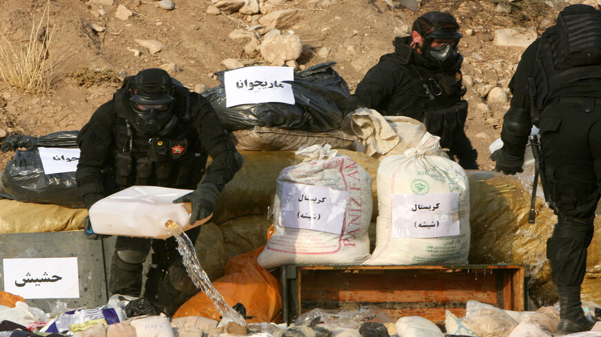 Members of the Iraqi Kurdish security forces pour gasoline over seized drugs before its incineration, Erbil, Iraqi Kurdistan, Oct. 29, 2013.