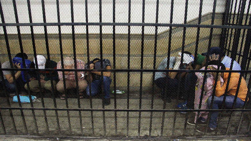 Eight Egyptian men on trial for doing a video prosecutors claimed was of a gay wedding hide their identities as they sit in the defendant's cage during their trial, Cairo, Egypt, Nov. 1, 2014.