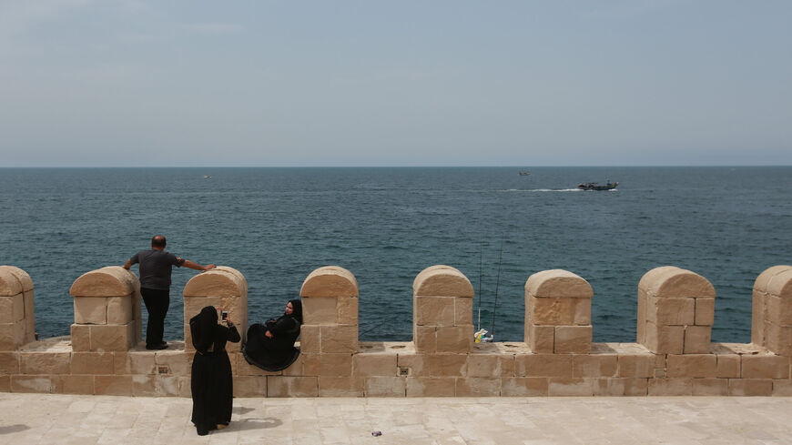 People look out over the Mediterranean Sea from the coastline of Alexandria, Egypt, May 21, 2016.