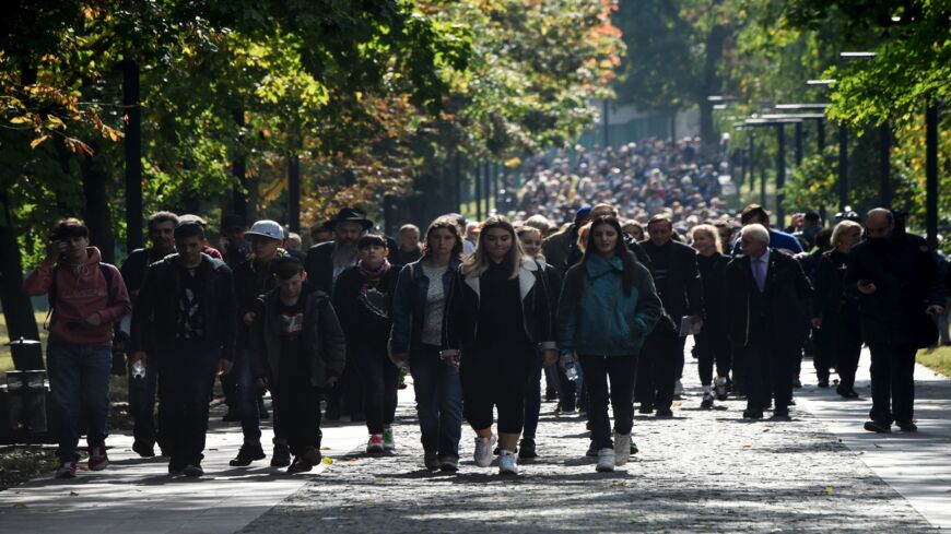 People walk toward the menorah monument at the Babyn Yar Holocaust Memorial in Kyiv, Ukraine, on Sept. 29, 2019