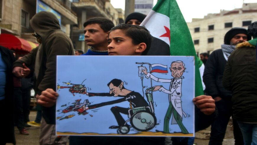 A Syrian holds a caricature of Bashar al-Assad and Vladimir Putin in a demonstration against the continuing assault by the Syrian regime and Russian forces in Idlib on Feb. 21, 2020.