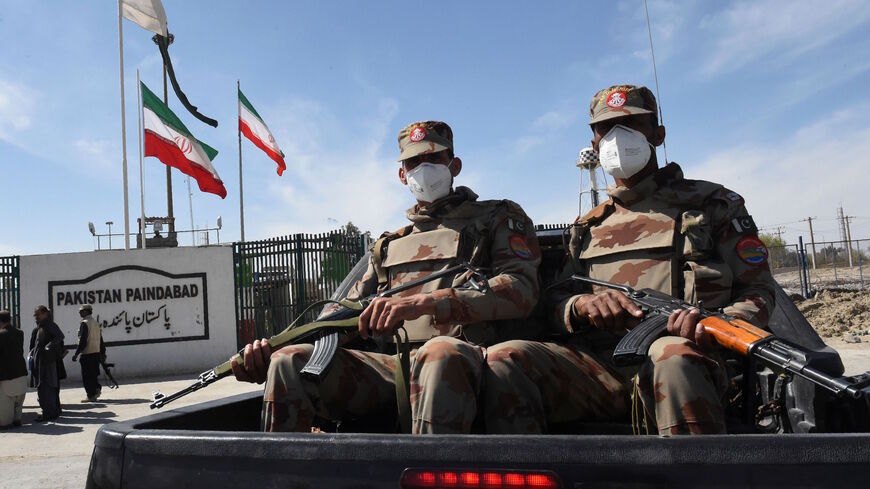 Pakistani soldiers wearing facemasks patrol near the closed Pakistan-Iran border in Taftan on Feb. 25, 2020 as fears over the spread of the COVID-19 coronavirus escalate following an outbreak in neighboring Iran. 