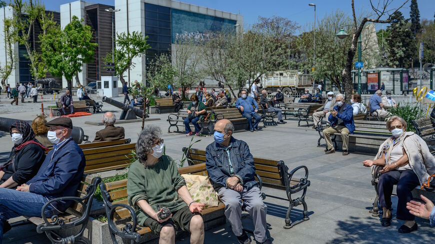 Elderly people wearing a protective face mask, sit and look at the Bosphorus on May 10, 2020, at Besiktas, Istanbul, after a month and a half of lockdown restrictions aimed at stemming the spread of the novel coronavirus.