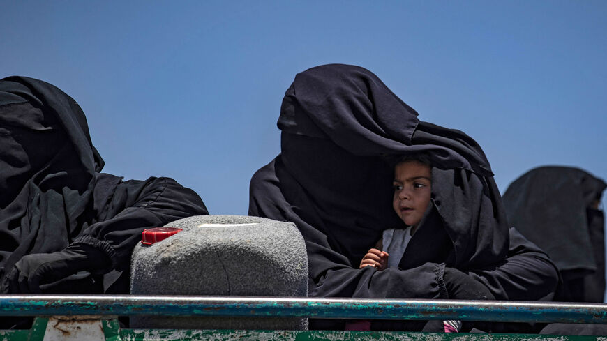 Syrian families sit in a truck after being released from the Kurdish-run al-Hol camp, which holds relatives of suspected Islamic State fighters, Hasakah governorate, Syria, June 2, 2021.