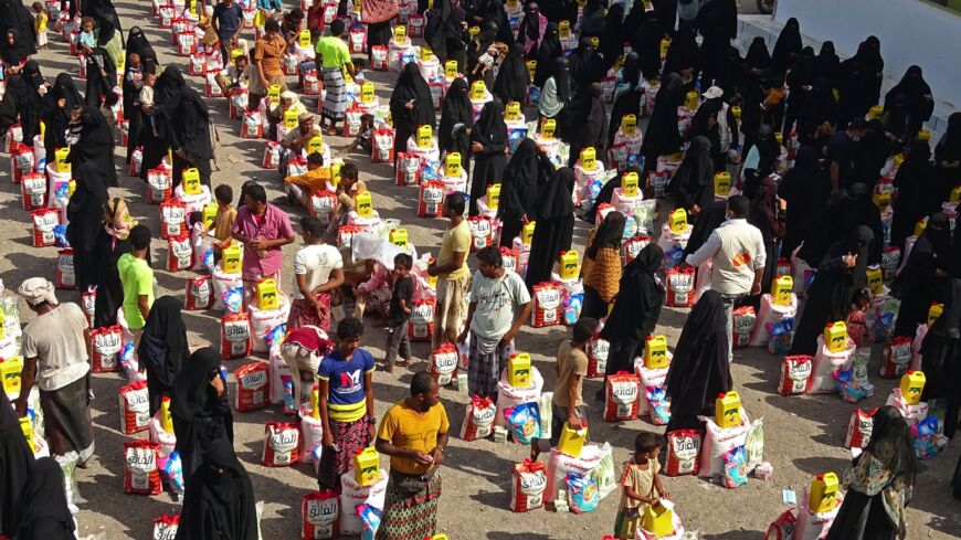 Those displaced by conflict receive food aid in the Tuhayta district of Yemen's war-ravaged Hodeidah province, on June 30, 2021.