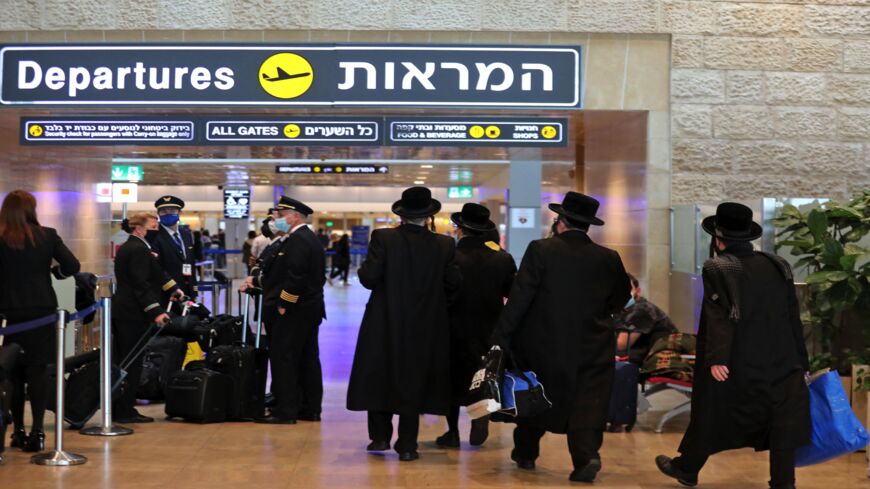 Ultra-Orthodox Jewish travelers walk to their departing flights at Israel's Ben Gurion Airport in Lod, east of Tel Aviv, on Dec. 21, 2021. 