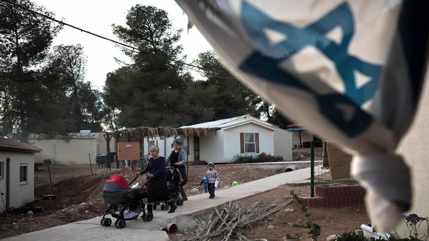 Members of the new Jewish community of Hiram walk with their children in their temporary village in Mahane Yatir located in the northern Negev Desert, Nov. 24, 2013.