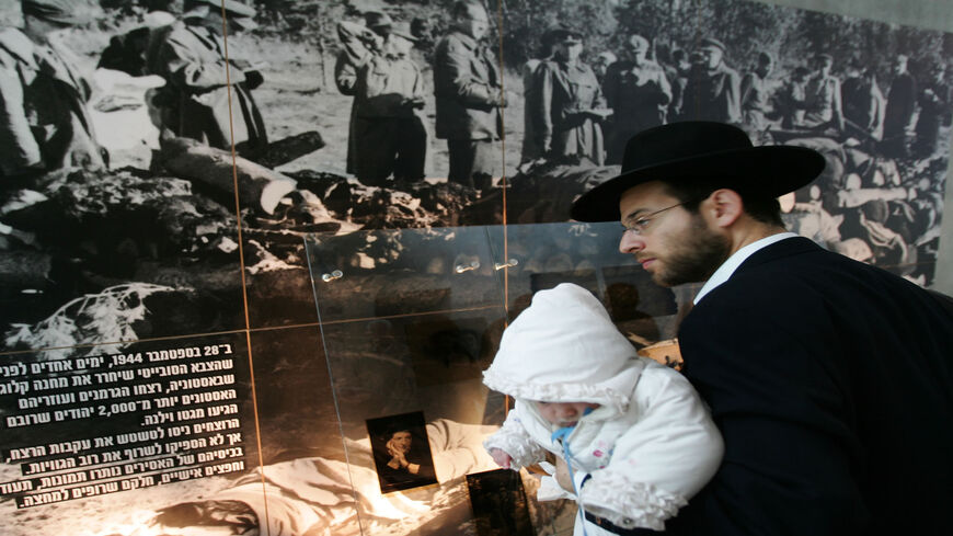 An ultra-Orthodox Jew carries his infant child through the Yad Vashem Holocaust Memorial Museum, Jerusale, May 4, 2005.