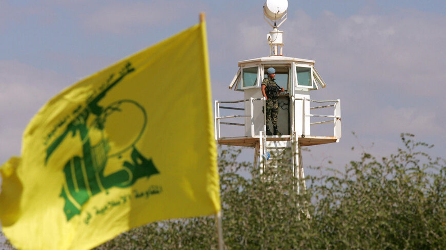 A Hezbollah flag flies in the foreground as a member of the Spanish contingent of the United Nations Interim Force in Lebanon (UNIFIL) stands in a lookout tower on Oct. 2, 2008 near the southern Lebanese village of Abbassiyeh near to the disputed Israeli-occupied Shebaa Farms area.  
