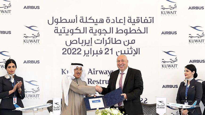 A photo provided by the Kuwaiti news agency KUNA shows the Chairman of Kuwait Airways Ali Al-Dukhan (C-L) shaking hands with Mikail Houari, President of Airbus Africa and Middle East, after signing a deal at the Kuwait Airways headquarters