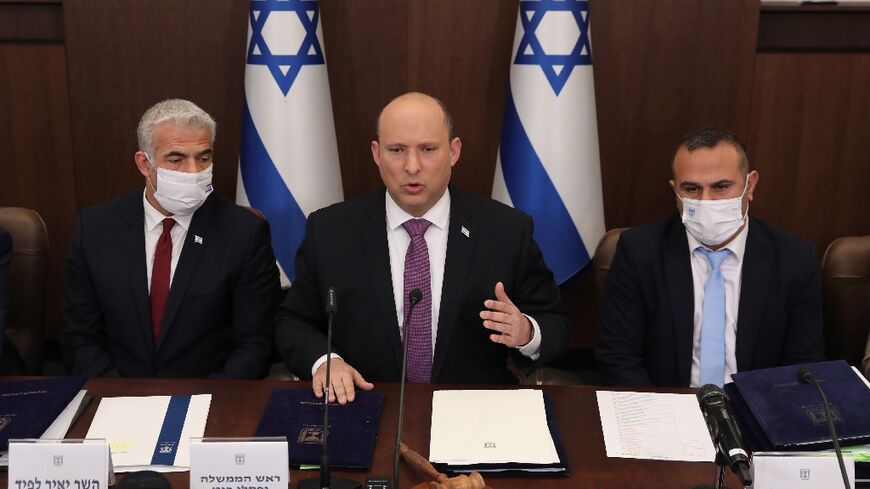 Israeli Prime Minister Naftali Bennett, in the centre,  Foreign Minister Yair Lapid, on the left, and Government Secretary Shalom Shlomo attend a cabinet meeting in Jerusalem on February 27, 2022