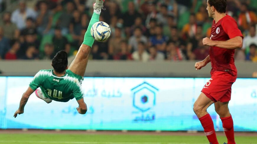 Iraq's midfielder Amjad Attwan performs an overhead kick during the 2022 World Cup qualifier against Hong Kong at Basra in 2019, when FIFA briefly lifted its ban on international matches in Iraq