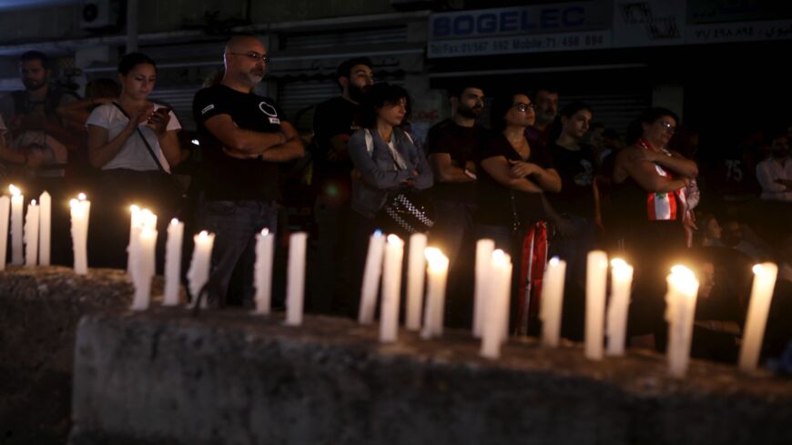 Lebanese anti-government protesters take part in a candlelight vigil outside the headquarters of Lebanon Electricity company in Beirut on Nov. 11, 2019.  