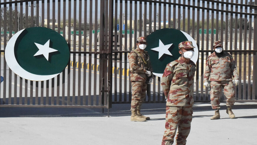 Pakistani soldiers wear facemasks on the closed border of Pakistan-Iran in Taftan, as fears over the spread of the coronavirus escalate following an outbreak in neighboring Iran, Feb. 25, 2020.
