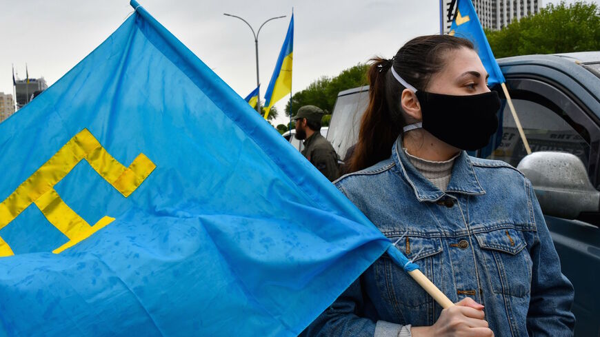 Participants gather with Ukrainian flags and flags of Crimean Tatars before riding in their cars through Kiev to commemorate the 76th anniversary of the deportation of the indigenous population of the Crimea by the Soviet Union, on May 18, 2020. 