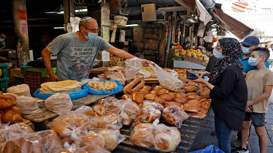 Shoppers buy bread at the Mahane Yehuda market, a day ahead of a nationwide lockdown aimed at curbing a surge in coronavirus cases, Jerusalem, Sept. 24, 2020.