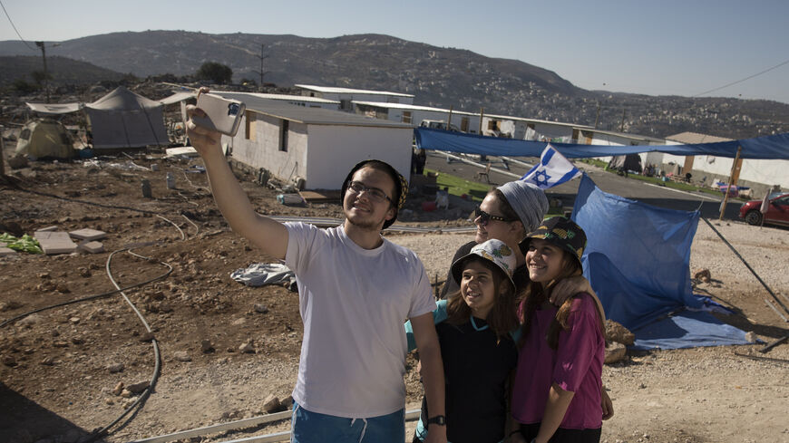 Jewish Israeli settlers pose for a photo at the recently established outpost of Evyatar on July 2, 2021 near Jabal Subeih, West Bank.